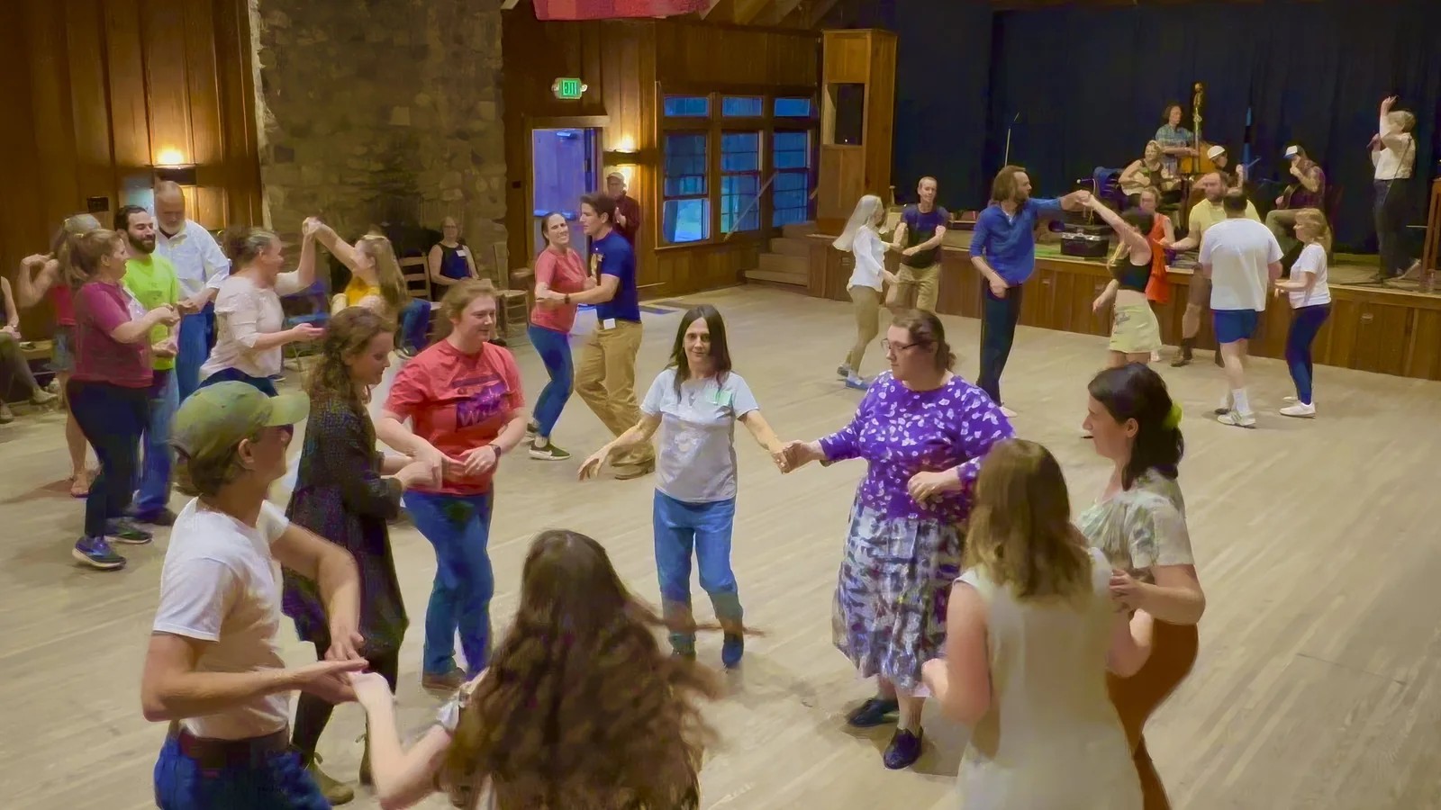 A group of adults moving through a square dance formation