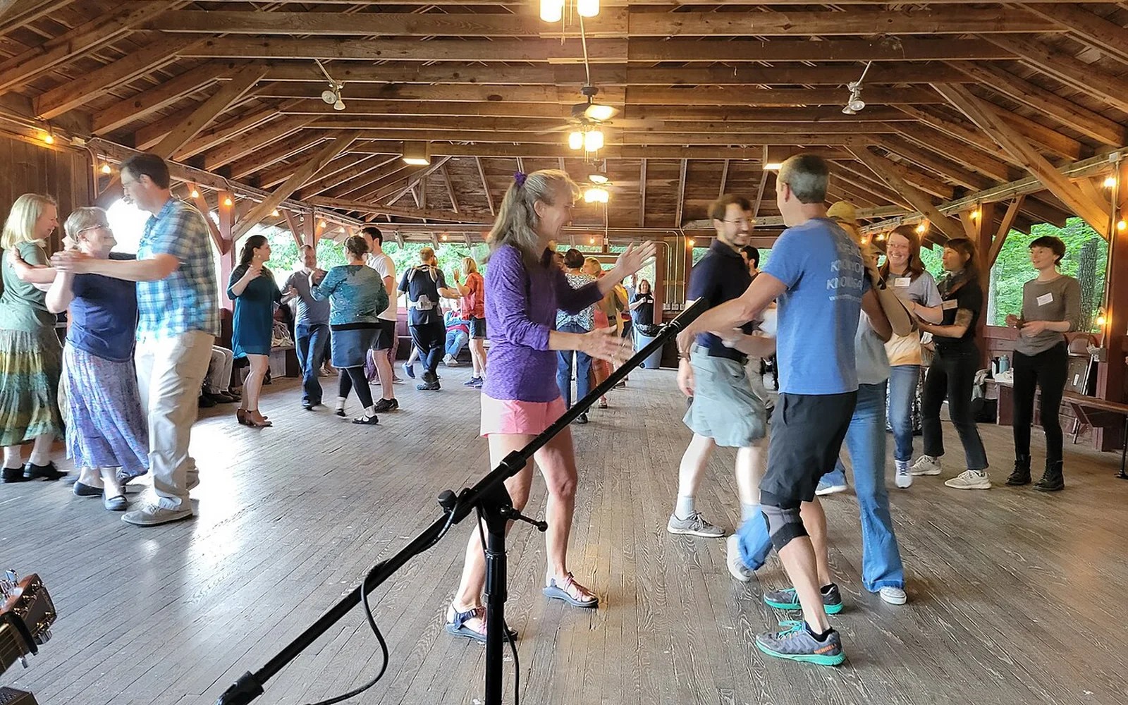 Adults enjoying a lively square dance in a wooden dance hall
